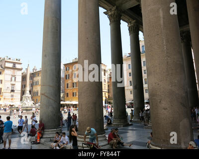 Les touristes à l'extérieur du panthéon reposent à l'ombre des colonnes sur la Piazza della Rotonda, Rome, Italie Banque D'Images