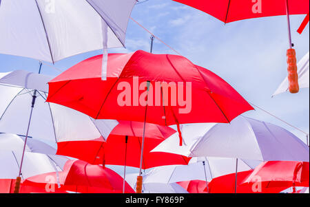 Des parasols multicolores suspendus sur ciel bleu. Et rouge avec une grande taille de parasols sur le ciel bleu. Banque D'Images