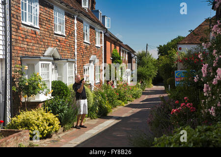 UK, Kent, Tenterden, Bells Lane, man photographing joli petit jardin fleuri de tuile maisons suspendues Banque D'Images