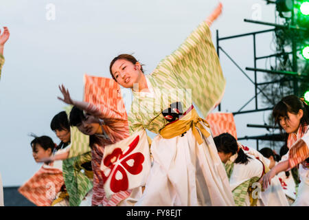 Jeune japonaise en remuant, manches longues, une partie de l'équipe de danse, danse sur scène en soirée pendant la danse Yosakoi Festival à Kumamoto, au Japon. Banque D'Images