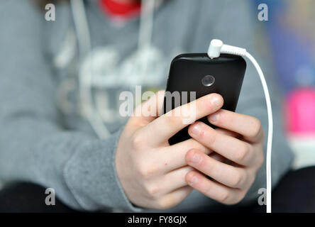 Teen holding mobile (cellulaire) téléphone en mains Banque D'Images