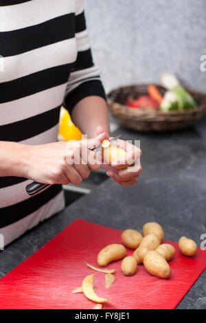 Pelures de pommes de femme dans la cuisine Banque D'Images