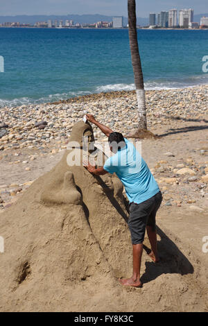 Mexican man carving une sculpture de sable sur la plage de Puerto Vallarta Malecon Banque D'Images