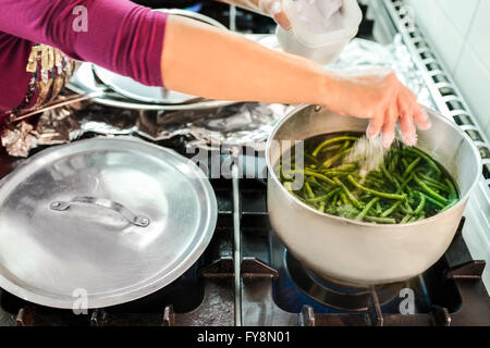 Haricots verts en ébullition femme cuisine cantine Banque D'Images