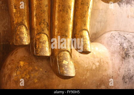 Bout Des Doigts d'une ancienne statue de Bouddha recouvert de peinture or, la Thaïlande. Banque D'Images