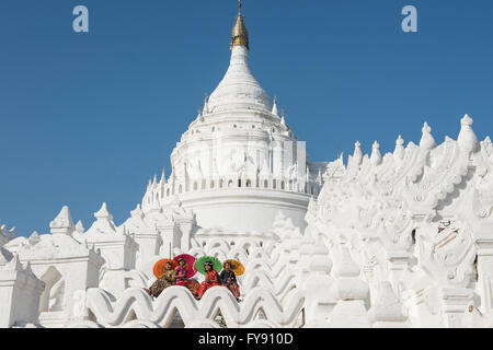 Des femmes fidèles avec des parasols en remontant la pagode hsinbyume, Mingun, Myanmar Banque D'Images