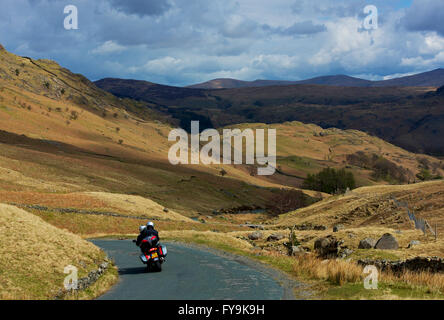 Couple en moto descendant le Col de Honister (B5289), parc national de Lake District, Cumbria, Angleterre Banque D'Images