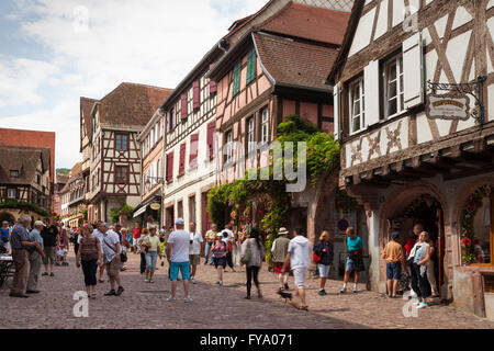 Maisons à colombages et les touristes dans la Rue du Général du Gaulle, Riquewihr, Alsace, France Banque D'Images