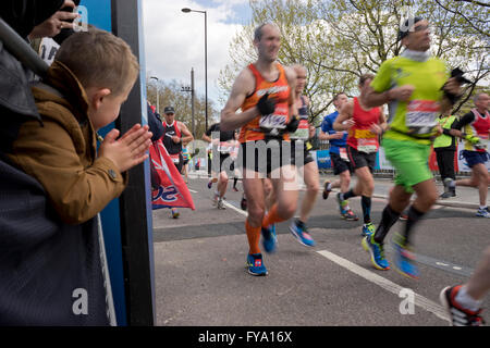 Porteur et d'un jeune spectateur près de Tower Bridge au Marathon de Londres 2016. UK Banque D'Images