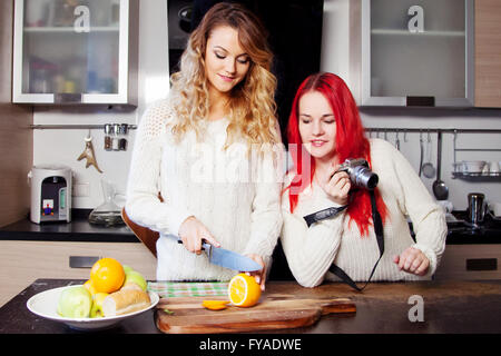 Deux jeunes femmes en cuisine, le chef et blogger. Couper le fruit de fille Banque D'Images