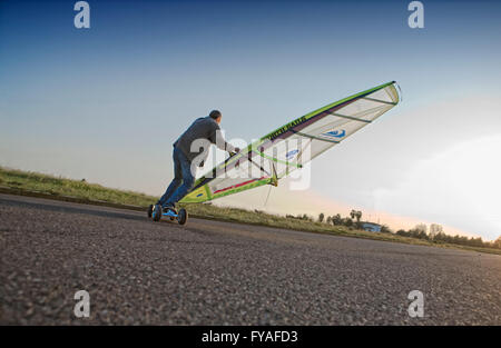 BADAJOZ, Espagne, le 27 mars. Un sportif équitation son skate par l'asphalte d'un parking du stade au coucher du soleil, le 27 mars 2012, Badajo Banque D'Images