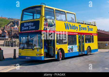 Un jaune vif garni ouvert bus à impériale qui emmène les touristes sur un tour autour de la station balnéaire de Whitby Banque D'Images