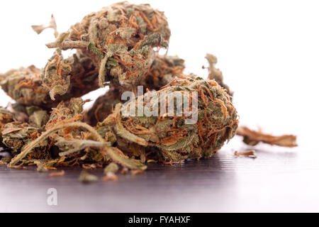 Close up cannabis séché ou feuilles de marijuana utilisée pour la médecine ou de médicaments psychoactifs sur le dessus de la table Banque D'Images