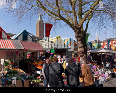 Les consommateurs à un étal de fruits et légumes sur le marché de Norwich dans le Norfolk Banque D'Images