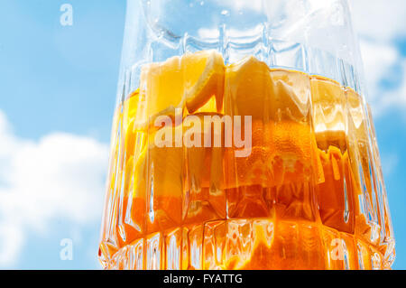 Accueil rafraîchissante faite orange tangerine et limonade citron ou de sangria dans verseuse en verre sur fond de ciel bleu Banque D'Images