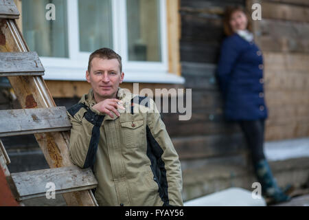 Young man smoking a cigarette, debout près de la ferme. Banque D'Images