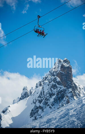 Un groupe de skieurs sur un télésiège en face de l'aiguille du fruit dans la station de ski de Courchevel, dans les Alpes françaises. Banque D'Images