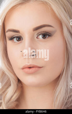 Close up of a blonde adolescentes face avec nez piercing. Banque D'Images