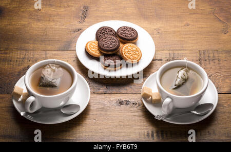 Servir le thé et de brassage.Ensemble de deux tasses de thé en céramique avec des sachets de thé et les plaques de cookies. Banque D'Images