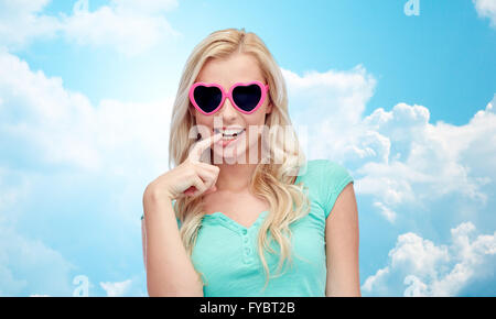 Happy young woman in heart shape sunglasses Banque D'Images