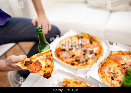 Close up of man eating pizza à la bière à la maison Banque D'Images