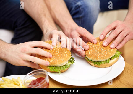 Close up of male hands avec des hamburgers sur la table Banque D'Images