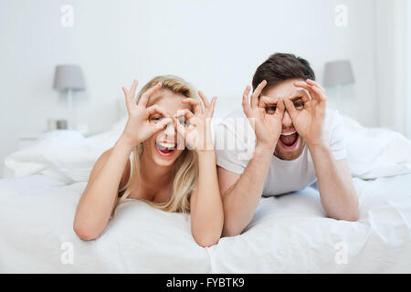 Heureux couple lying in bed at home Banque D'Images