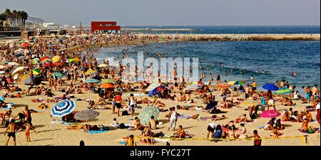 Plage bondée en été, rempli de parasols colorés à Barcelone, Espagne. Banque D'Images