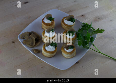 Vol au vent avec la crème de champignons, comme apéritif plat sur table en bois Banque D'Images