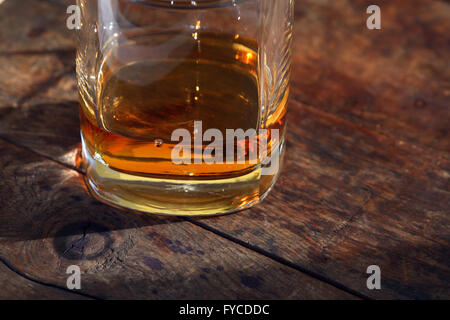 Verre de whisky chevronnés sur la surface en bois sous la lumière du soleil Banque D'Images