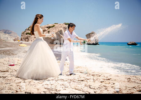 Mariée et le marié ouvrir champagne sur la plage Mer Méditerranée Banque D'Images