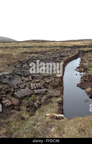 Boutures tourbeuses et tourbières entassées sur la terre tourbière à côté d'un cours d'eau sur Arranmore - la plus grande île habitée du comté de Donegal Irlande. Banque D'Images