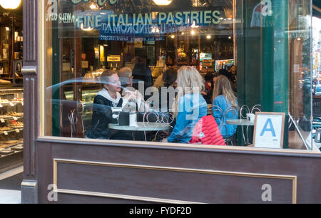 Deux jeunes femmes en attente d'être servi à l'Italienne café et pâtisserie au Caffe Roma sur Mulberry Street à Little Italy, New York City Banque D'Images