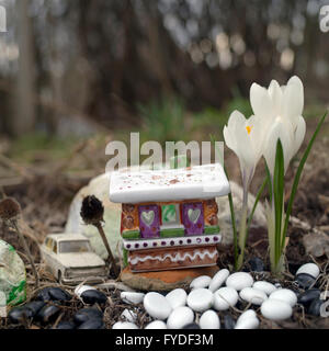 Jouet doux maison faite de porcelaine, beau crocus et voiture garée derrière elle, sélective focus macro shot Banque D'Images