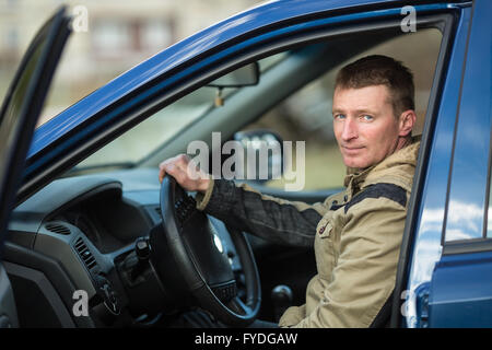 Jeune homme à l'origine d'une nouvelle voiture. Banque D'Images