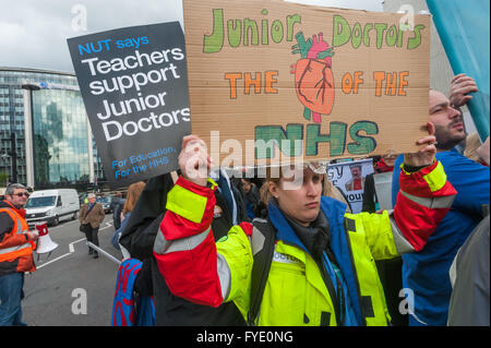 Londres, Royaume-Uni. 26 avril, 2016. Un médecin est titulaire d'une affiche avec un détail anatomique coeur au mois de mars par les médecins et les enseignants de St Thomas' Hospital à Downing St organisée par l'écrou et BMA à la fin de la première journée de la grève de deux jours par les médecins en formation. Leader du travail et Jeremy Corbyn Shadow Chancellor John McDonnell ont été à l'avant de la marche. Peter Marshall/Alamy Live News Banque D'Images