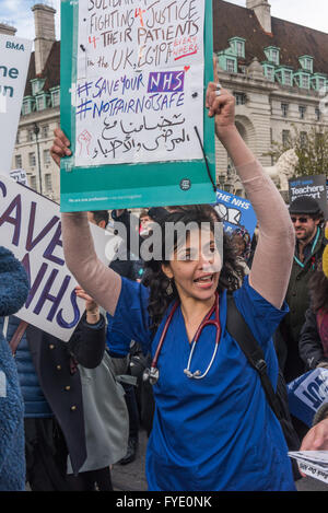 Londres, Royaume-Uni. 26 avril, 2016. Un médecin est titulaire d'un placard en anglais et en arabe sur le mois de mars par les médecins et les enseignants de St Thomas' Hospital à Downing St organisée par l'écrou et BMA à la fin de la première journée de la grève de deux jours par les médecins en formation. Leader du travail et Jeremy Corbyn Shadow Chancellor John McDonnell ont été à l'avant de la marche. Peter Marshall/Alamy Live News Banque D'Images