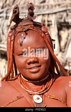 Les himbas sont un peuple nomade de la Namibie. Ils se parer avec cuir et anneaux en laiton et enduire la peau avec une pâte faite de beurre et du bois. Filles portent deux épaisses tresses tresse, face avant et se redressa au-dessus du front comme des cornes, Namibi Banque D'Images