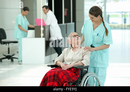 Infirmière de l'hôpital en poussant une vieille dame dans un fauteuil roulant Banque D'Images