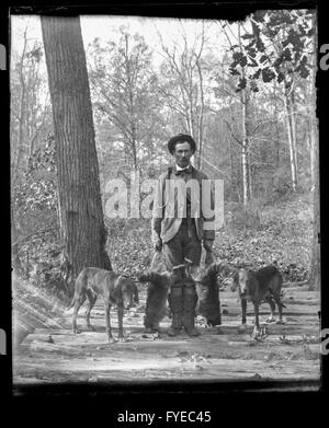 Photographie victorienne d'un chasseur avec ses chiens et les ratons laveurs morts à Fallston, Maryland. Banque D'Images