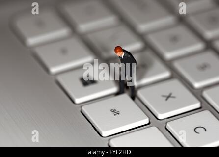 Un homme d'affaires figurine miniature debout sur un clavier d'ordinateur portable Banque D'Images