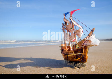 Modèle de navire sur la plage ensoleillée d'été. Billet d Banque D'Images