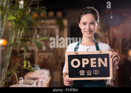 Propriétaire de la maison de thé holding open sign Banque D'Images