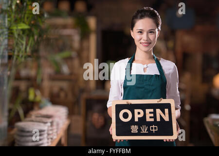Propriétaire de la maison de thé holding open sign Banque D'Images
