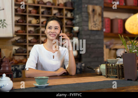 Propriétaire de la maison de thé à l'aide de smart phone Banque D'Images