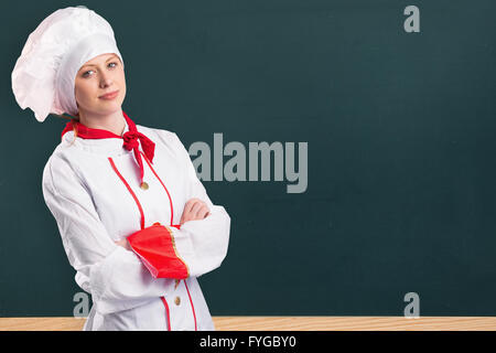 Image composite de jolie chef standing with arms crossed Banque D'Images