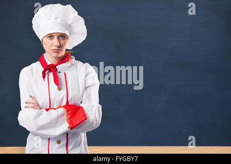 Image composite de jolie chef standing with arms crossed Banque D'Images