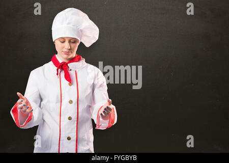 Image composite de jolie chef standing with hands out Banque D'Images