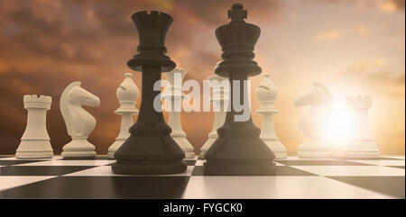 Image composite du roi noir et de la reine debout devant des pièces blanches Banque D'Images