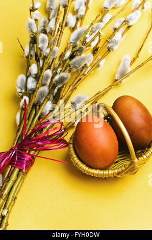 Bouquet de branches de saule et deux oeufs de Pâques dans le panier Banque D'Images